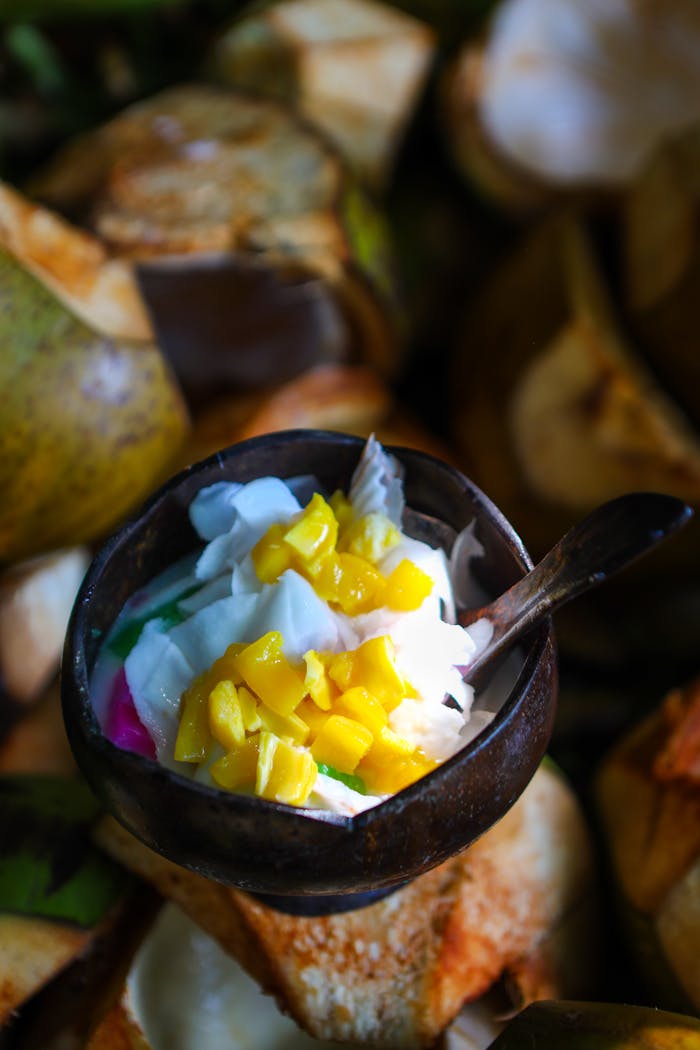 gallery-3 Delicious coconut dessert topped with vibrant mango pieces, set against a natural backdrop in Indonesia.