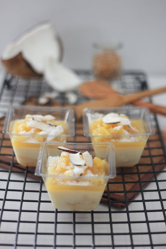 gallery-6 Tropical coconut and mango parfaits in clear cups on a cooling rack.